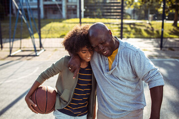 Grandfather and grandson bonding on basketball court outdoors