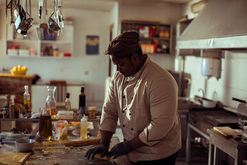 Black chef preparing fresh pasta in professional kitchen