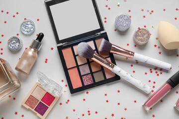 Composition with jars of glitter, confetti, makeup products and brushes on white background