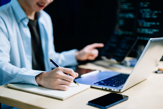 Asian software developer working late with code on screens, tablet, and phone. Concept of programming, tech lifestyle,