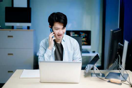 Asian software developer working late with code on screens, tablet, and phone. Concept of programming, tech lifestyle,
