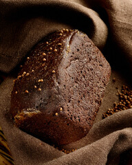 Loaf of rye bread with caraway seeds on a dark background