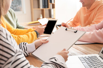 Young people negotiating at table in office, closeup