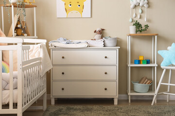 Interior of nursery with commode, crib and shelf units