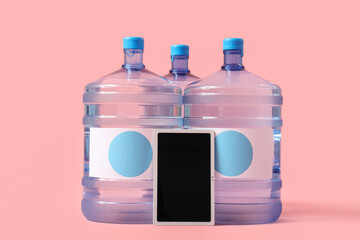 Bottles of clean water with blank tablet computer on pink background