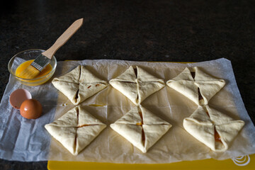 preparing filled puff pastrys for baking in the oven