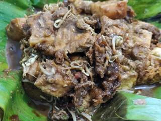Tahu lontong, a delicious traditional Indonesian dish, lontong with peanut sauce, soy sauce, served with pieces of side dish on banana leaves.