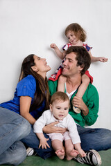 Happy Family Smiling Together with Young Children Against White Background