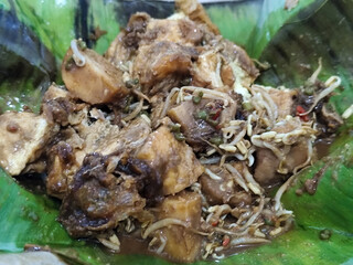 Tahu lontong, a delicious traditional Indonesian dish, lontong with peanut sauce, soy sauce, served with pieces of side dish on banana leaves.