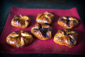 fresh baked filled puff pastry on a silicon mat, to coffee time a homemade sweet pastry