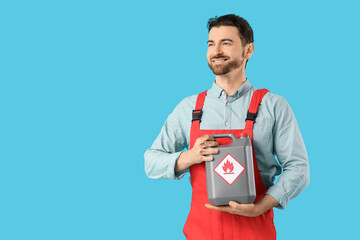 Male mechanic with canister on blue background