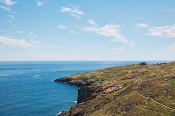 Scenic Coastal Landscape of Madeira with Cliffs, Ocean, and Hiking Trail on a Sunny Day