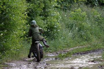 Boys in waterproof clothes and rubber boots ride fatbikes. A fat bike for off-road use