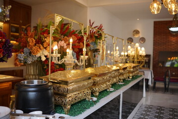 Elegant Buffet Setup Luxurious Food Presentation with Golden Chafing Dishes and Floral Arrangements