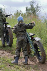Boys in waterproof clothes and rubber boots ride fatbikes. A fat bike for off-road use