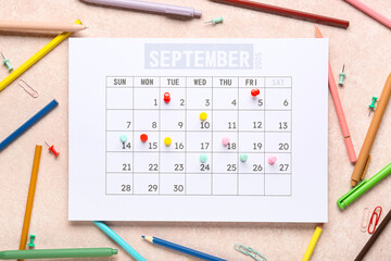 Calendar with stationery and pins on grunge pink background. Planning concept