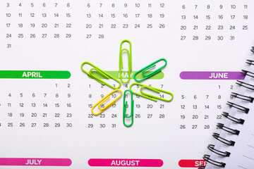 Calendar with paper clips as background, closeup. Planning concept