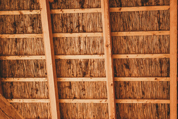 Rustic Ceiling with Dense Thatched Roofing and Vertical Wooden Supports