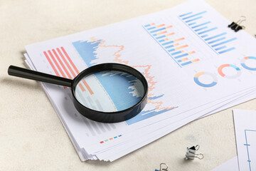 Magnifier with binder clips, many business documents and graphics on white background