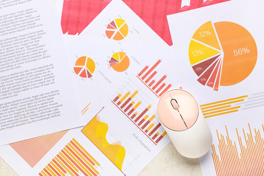 Computer mouse with many business documents and graphics as background, closeup