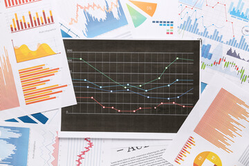 Many business documents with graphics as background, closeup