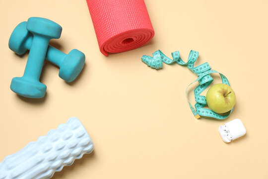 Set of sports equipment on beige background, top view