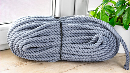 Gray Coiled Utility Rope on Indoor Surface - Ideal for Construction, Camping, and Craft Use