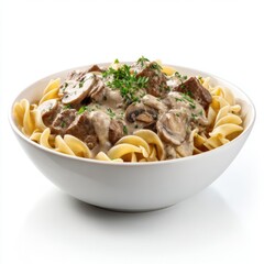 Hearty beef and mushroom stroganoff served over wide egg noodles garnished with fresh parsley in a white ceramic bowl on a white background