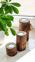 Set of Old Log Candle Holders with Tealights in a Natural Interior Setting