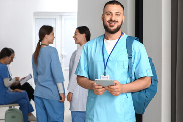 Male medical intern with tablet computer in hall