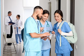Group of medical interns with clipboard in hall
