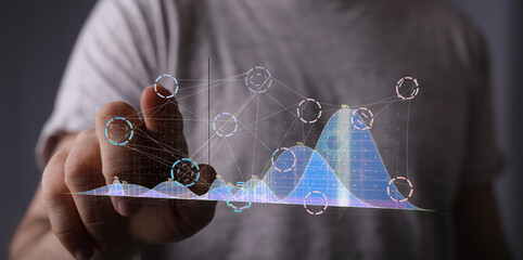 A businessman interacts with a holographic graph, analyzing data and market trends.