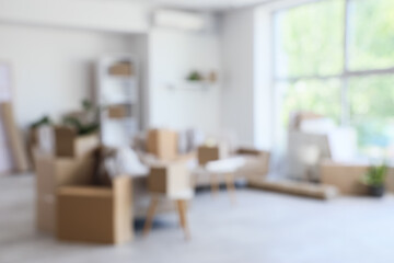 Blurred view of sofas with cardboard boxes in living room on moving day