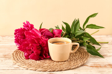 Beautiful peony flowers and cup of hot coffee on white wooden against yellow background