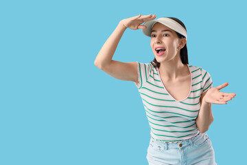 Fototapeta premium Happy young woman in summer cap on blue background