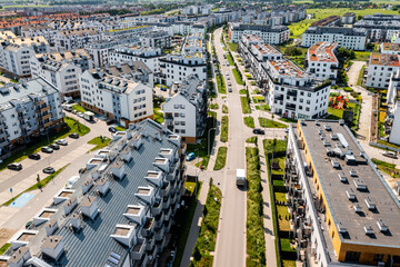 Bird's-eye view of dense suburban apartment complex with streets and housing blocks surrounded by...