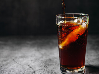 Pouring of Cola and Ice, Cola soft drink with ice cubes, soda fizzy drink in Cold glass