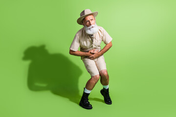 Photo of old traveler senior man scout touch belly waist suffer horrible pain isolated green color background
