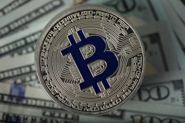 Cryptocurrency. Many bitcoins on dollar banknotes, top view