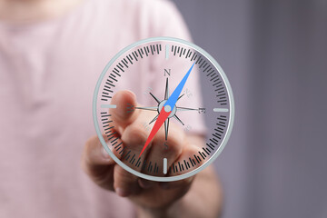 Hand pointing at a digital compass screen, showing direction and navigation. Ideal for business,...