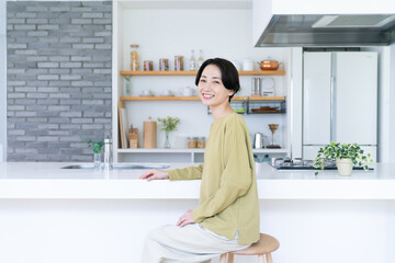 キッチンでくつろぐミドルの女性