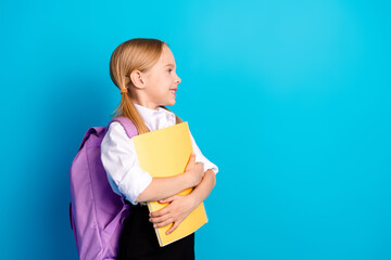 Happy schoolgirl with backpack and notebook on blue background symbolizing education and learning
