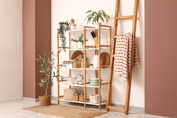 Interior of kitchen with wooden shelf unit, ladder and plants