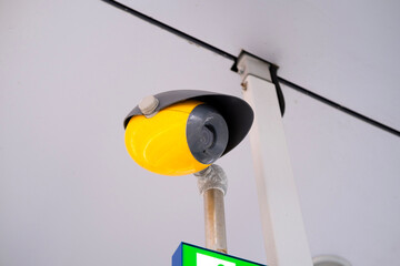 Perimeter security system with Modern surveillance yellow camera on pole, overlooking restricted...