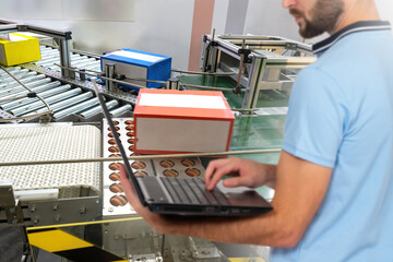 Man production line operator. Conveyor inside distribution warehouse. Cropped production line...