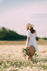Daisy field flowers, woman, nature. Walks at day with daisies on head basket in flower field.
