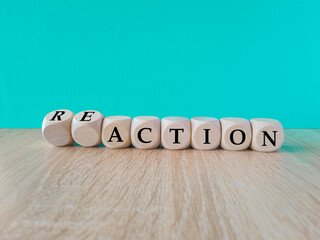 Turned wooden cubes and changes the word action to reaction. Beautiful blue background, wooden...