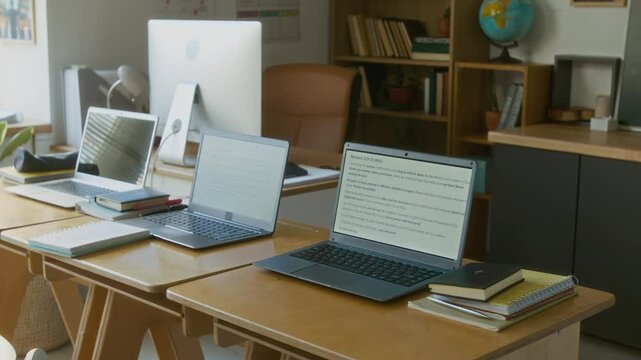 No people shot of laptops with Bible quotes on desk in modern well-equipped classroom during computer science lesson in religious school