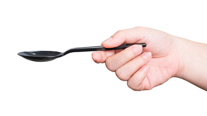 Female hand holding a black plastic spoon isolated on white background.
