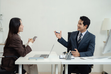 Business team analyzing documents, graphs, and data with a laptop, tablet, and smartphone. Collaboration, strategy, and success in a modern office.